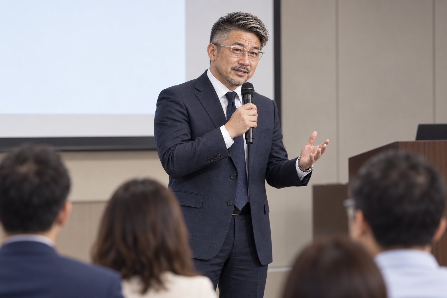 セミナー会場の前方でマイクを持って説明する金昌秀を描いたAI生成イメージ